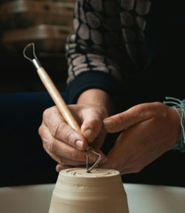 person holding white plastic cup with brown liquid